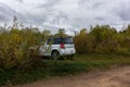 Universal white crossover car parked for travelers on the territories of coastal reserves in the Pskov region, west of the Izborsk