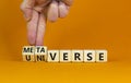 Universe or metaverse symbol. Businessman turns wooden cubes and changes the word universe to metaverse. Beautiful orange table
