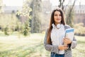 University college student girl looking happy smiling with book or notebook in campus park. Caucasian young woman female model. Royalty Free Stock Photo