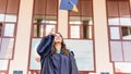 University graduates  throwing graduation hats in the air. Group of happy graduates in academic dresses near university building Royalty Free Stock Photo