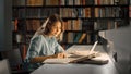 University Library: Beautiful Smart Caucasian Girl uses Laptop, Writes Notes for Paper, Essay, Stu Royalty Free Stock Photo