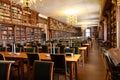 University Library interior with many student desks and bookshelf with ancient books