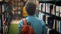 University Library: Student Walks Between Rows of Bookshelves Searching for the Right Book Title f Royalty Free Stock Photo