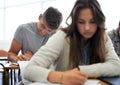 University, man and woman in classroom writing test with learning, opportunity and future. Education, knowledge and Royalty Free Stock Photo