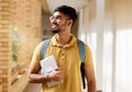 University student, college and indian man with a tablet and backpack while walking down campus corridor. Young gen z Royalty Free Stock Photo