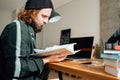 University student leaf through a book while going online lesson Royalty Free Stock Photo