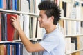 University student selecting book from library she Royalty Free Stock Photo