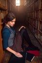 University student sitting on a floor of library.