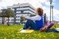 University student studying with laptop on campus lawn, enjoying spring day Royalty Free Stock Photo