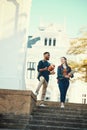 University, students and friends with a woman and man walking down stairs on campus for education. Learning, books and Royalty Free Stock Photo