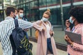 Students standing and greeting bumping elbows outdoors, coronavirus and back to normal concept.to normal concept Royalty Free Stock Photo