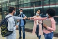 Students standing and greeting with a fist outdoors, coronavirus and back to normal concept Royalty Free Stock Photo