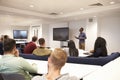 University students study in a classroom with male lecturer Royalty Free Stock Photo