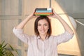 Univetsity research. Pretty woman working home. Girl portrait with book on head