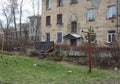 Unkempt dirty yard with garbage near old houses in the spring