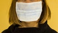 Unknown adult female is using single use hygenic face mask