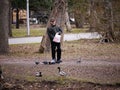 Unknown adult man feeds birds in Central Park of Saint-Petersburg in September 2017