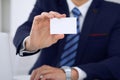 Unknown businessman or lawyer giving a business card while sitting at the table, close-up. He offering partnership an Royalty Free Stock Photo