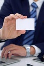 Unknown businessman or lawyer giving a business card while sitting at the table, close-up. He offering partnership an Royalty Free Stock Photo