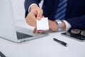 Unknown businessman or lawyer giving a business card while sitting at the table, close-up. He offering partnership an Royalty Free Stock Photo