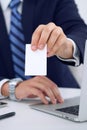 Unknown businessman or lawyer giving a business card while sitting at the table, close-up. He offering partnership an Royalty Free Stock Photo