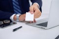 Unknown businessman or lawyer giving a business card while sitting at the table, close-up. He offering partnership an Royalty Free Stock Photo