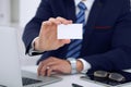 Unknown businessman or lawyer giving a business card while sitting at the table, close-up. He offering partnership an Royalty Free Stock Photo