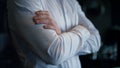 Unknown businessman standing dark restaurant interior. Closeup folded man hands