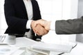 Unknown diverse business people are shaking hands finishing up meeting at the desk in office, close-up. Handshake Royalty Free Stock Photo