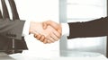 Unknown diverse business people are shaking hands finishing up meeting at the desk in office, close-up. Handshake Royalty Free Stock Photo