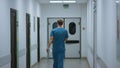 Unknown doctor walking down hospital corridor. Surgeon hurring to operation. Royalty Free Stock Photo