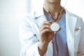 Unknown doctor woman holds stethoscope head, close-up. Physician ready to examine and help patient. Helping and