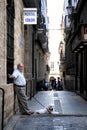 Unknown elderly man with a dog on a narrow street of the ancient city of Cadiz.