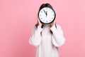 Unknown female hiding her face behind big wall clock, time management, schedule, meeting appointment Royalty Free Stock Photo