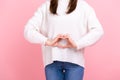 Unknown girl making heart shape in front of her belly as symbol of women health care, healthy eating Royalty Free Stock Photo