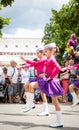 Unknown junior majorettes in pink and violet costumes with batons