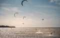 Unknown kitesurfers surf on brown water with waves from the Atlantic Ocean