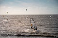 Unknown kitesurfers surf on brown water with waves from the Atlantic Ocean in La Rochelle, France Royalty Free Stock Photo