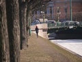 Unknown loney girl walking alonside embankment of the channel