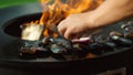 Unknown man grilling mussels outside. Male chef preparing seafood on mangal Royalty Free Stock Photo