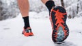 Unknown man running in snow in winter day close up on shoe sneakers Royalty Free Stock Photo