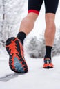 Unknown man running in snow in winter day close up on shoe sneakers Royalty Free Stock Photo