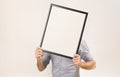 Unknown man wearing business shirt holding blank picture frame infront of his face Royalty Free Stock Photo