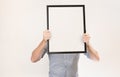 Unknown man wearing business shirt holding blank picture frame infront of his face Royalty Free Stock Photo