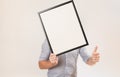 Unknown man wearing business shirt holding blank picture frame infront of his face Royalty Free Stock Photo