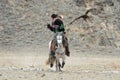 Unknown Mongolian Hunter So Called Berkutchi Astride On Horse And Flying Golden Eagle. Falconry In West Mongolia. Golden Eagle Royalty Free Stock Photo