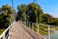 Unknown people walking on pedestrian bridge across Khorol river in wellness resort Myrhorod