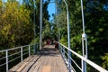 Unknown people walking on pedestrian bridge across Khorol river in wellness resort Myrhorod