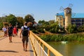 Unknown people walking on pedestrian bridge across Khorol river in wellness resort Myrhorod