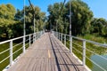 Unknown people walking on pedestrian bridge across Khorol river in wellness resort Myrhorod